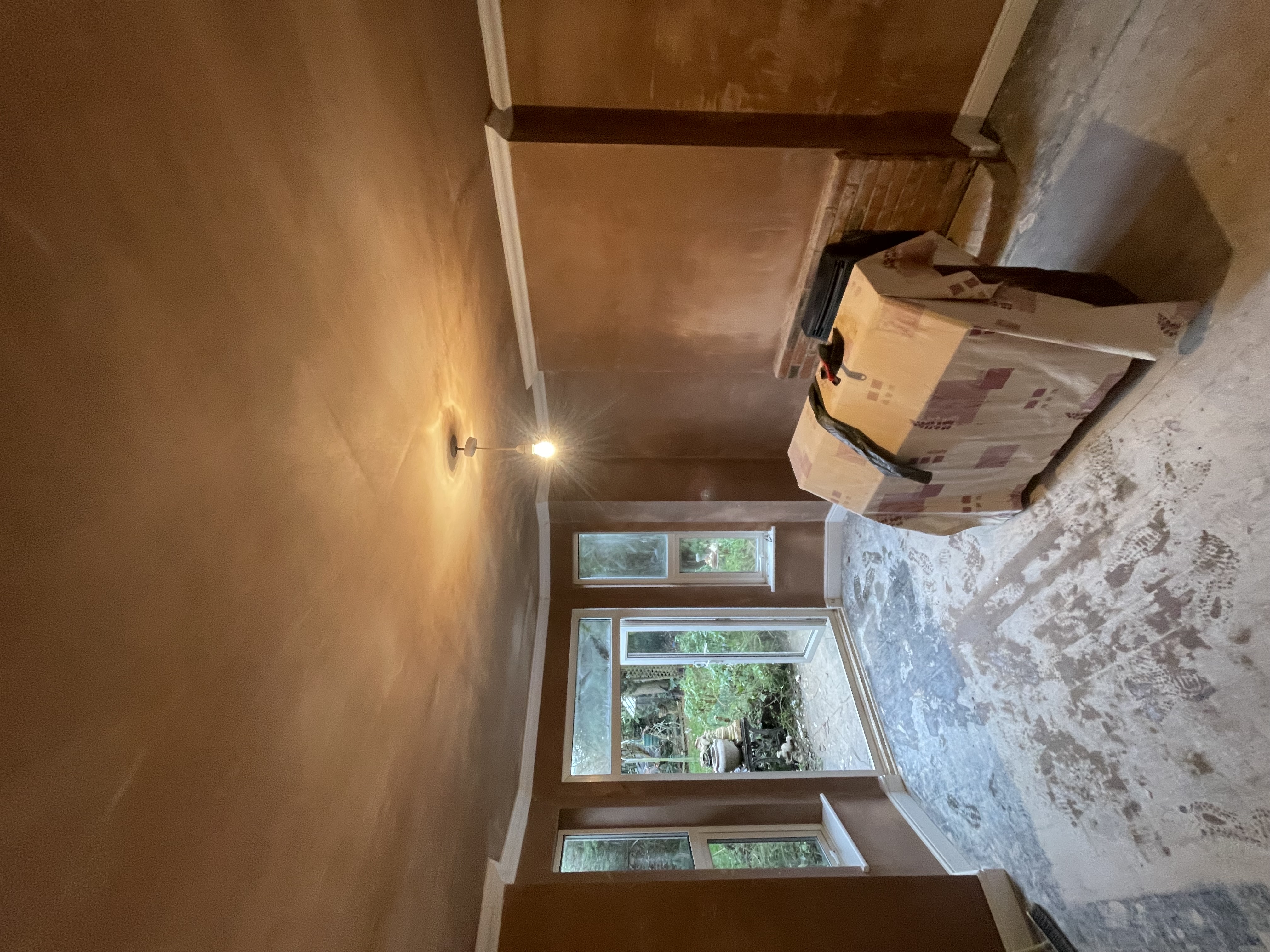Bay window room with fresh salt-retardant plaster applied to all walls and ceiling