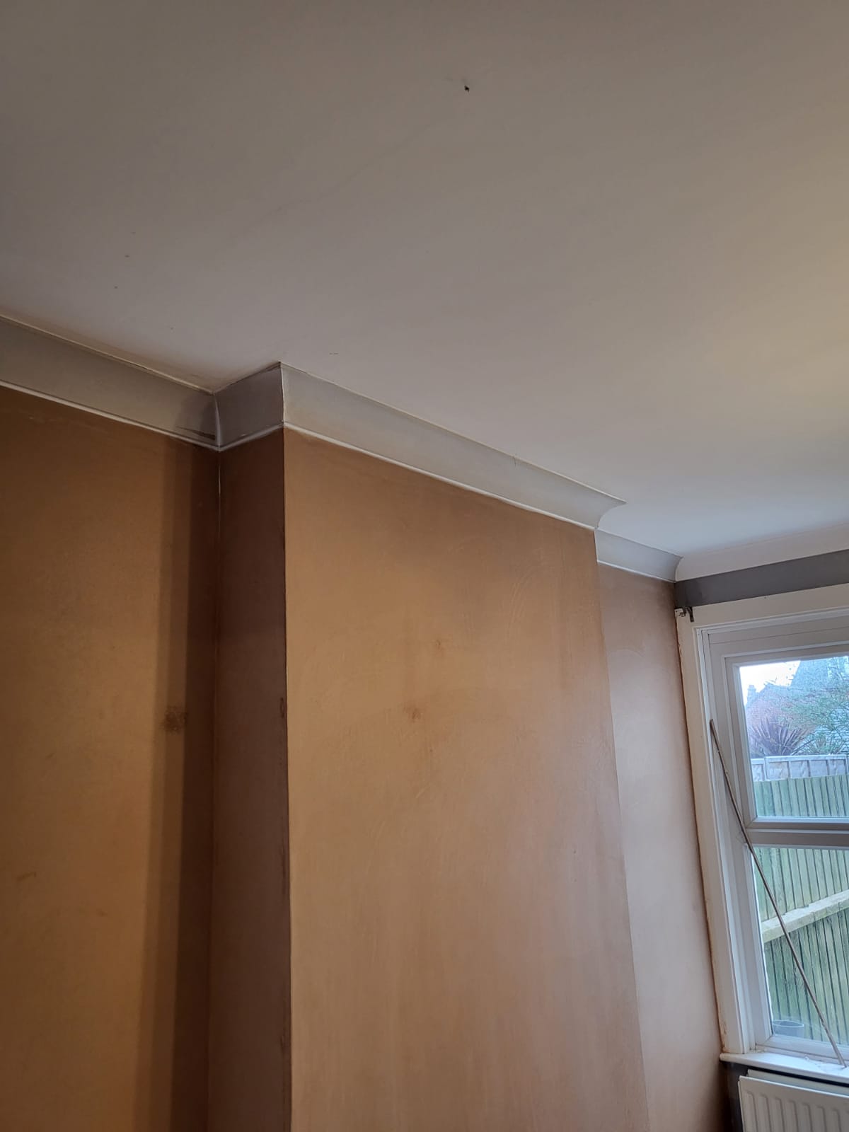 Fresh skim coat plaster on a wall corner showing smooth finish