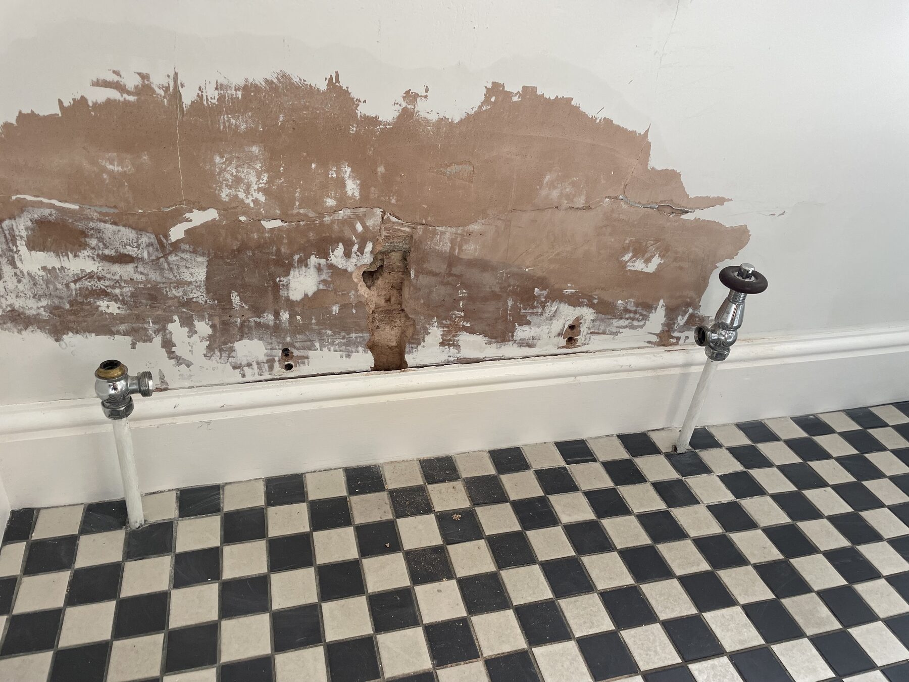 Plaster blown and falling away from a wall due to damp salt contamination