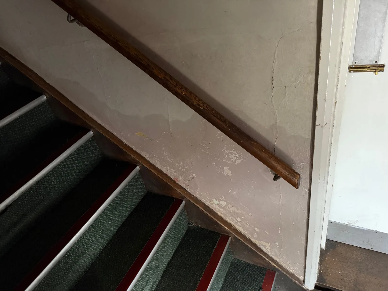 Rising damp tide marks and salt deposits on a staircase wall