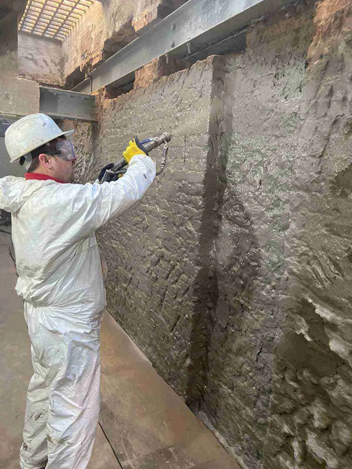 Cementitious slurry spray application for basement tanking